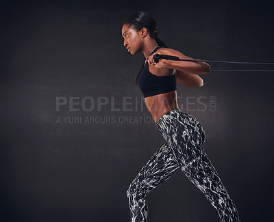 Buy stock photo Studio shot of a beautiful young woman working out against a black background