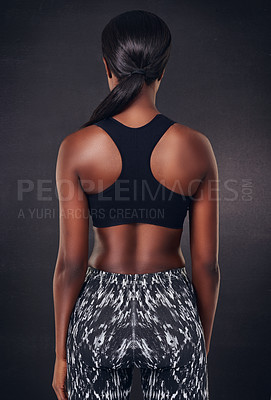 Buy stock photo Rearview studio shot of a woman wearing sports clothing against a black background