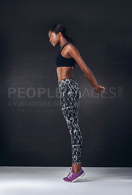 Buy stock photo Studio shot of a beautiful young woman working out against a black background