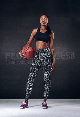 Buy stock photo Studio shot of a beautiful young woman holding a basketball against a black background