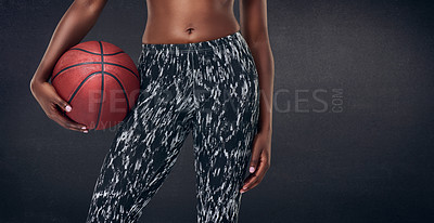 Buy stock photo Cropped studio shot of a woman holding a basketball against a black background