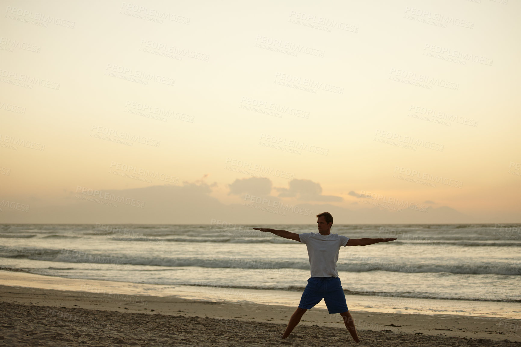 Buy stock photo Shot of a man doing yoga on the beach at sunset