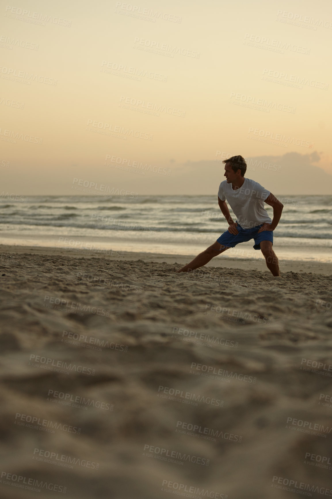 Buy stock photo Shot of a man doing yoga on the beach at sunset