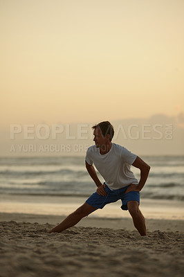 Buy stock photo Shot of a man doing yoga on the beach at sunset