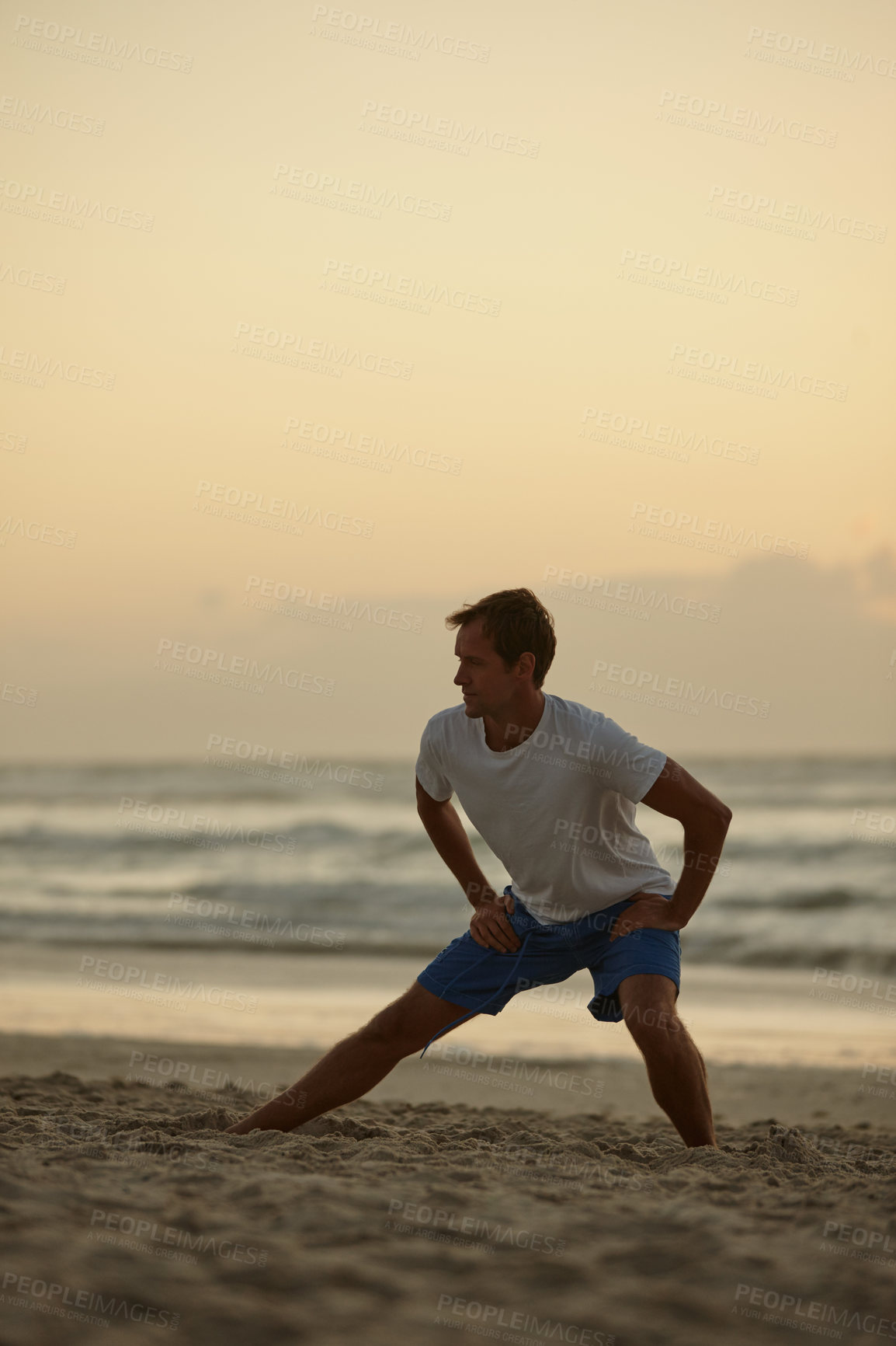 Buy stock photo Shot of a man doing yoga on the beach at sunset