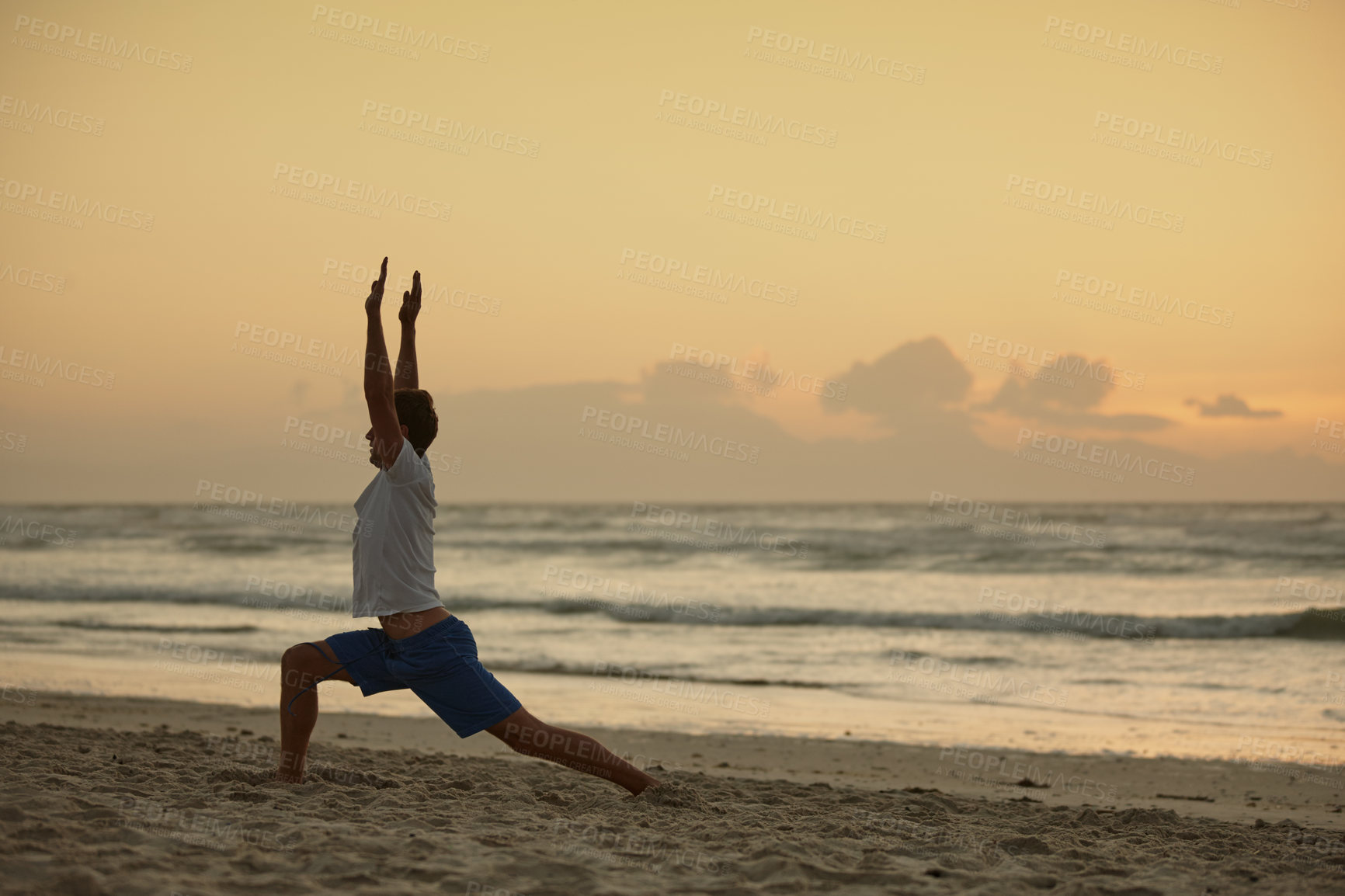 Buy stock photo Shot of a man doing yoga on the beach at sunset