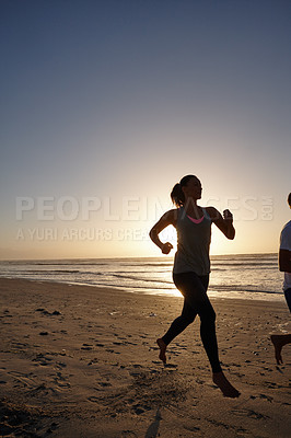 Buy stock photo Silhouette of a young woman running on the beach at sunset