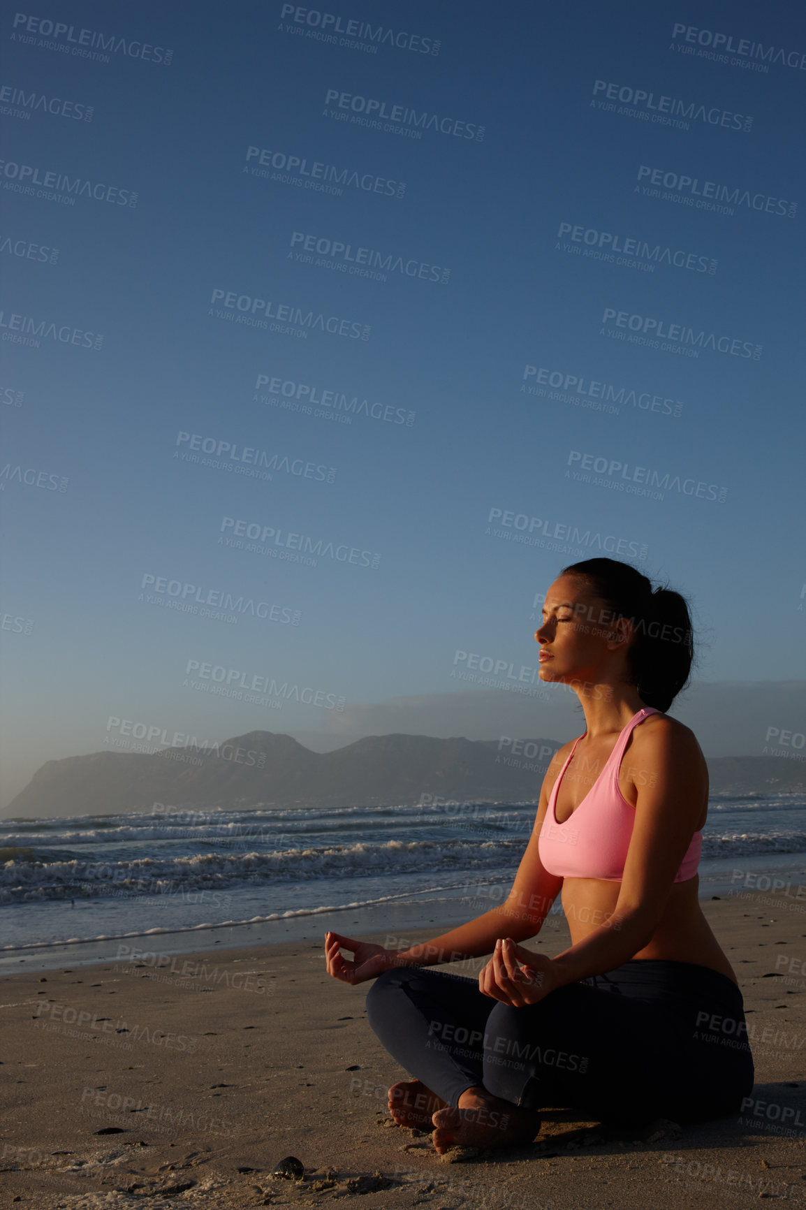 Buy stock photo Shot of a woman meditating on the beach