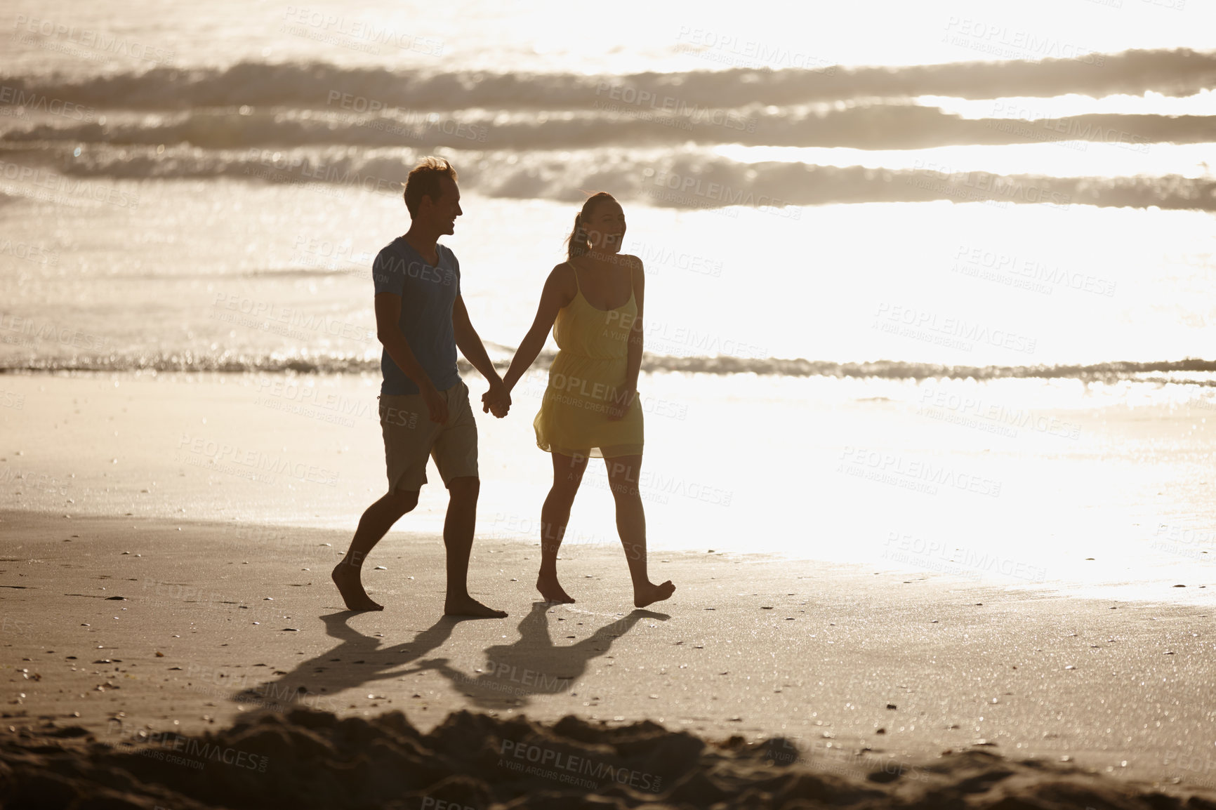 Buy stock photo Shot of an affectionate couple walking on the beach