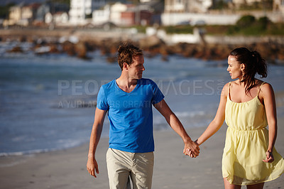 Buy stock photo Shot of an affectionate couple walking on the beach