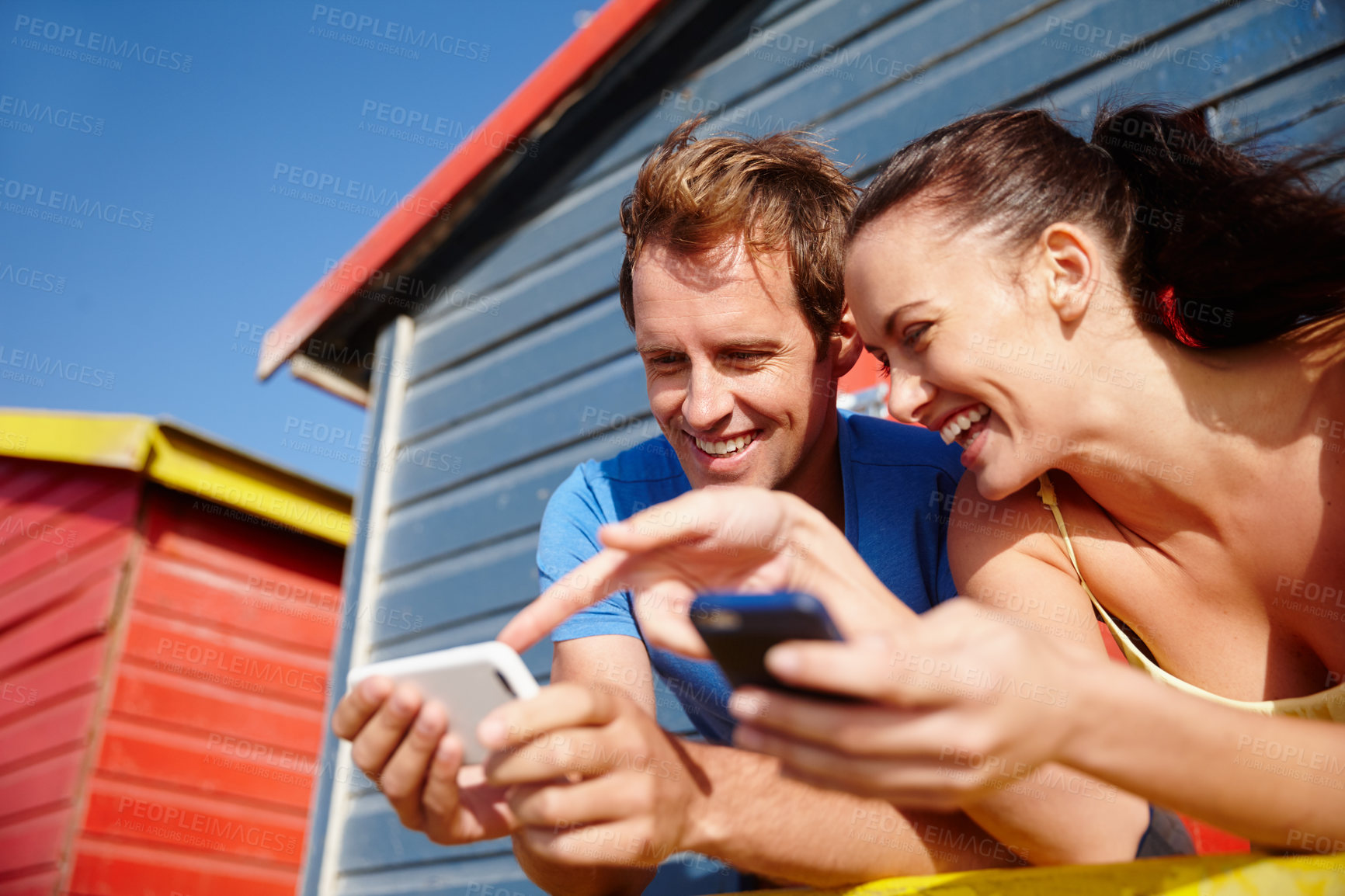 Buy stock photo Cropped shot of a couple looking at photos while on holiday