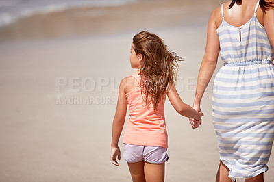 Buy stock photo A mother a daughter walking hand in hand on the beach