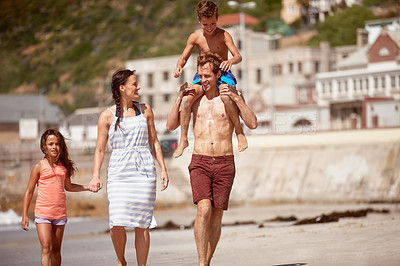 Buy stock photo Shot of a family enjoying a walk along the beach