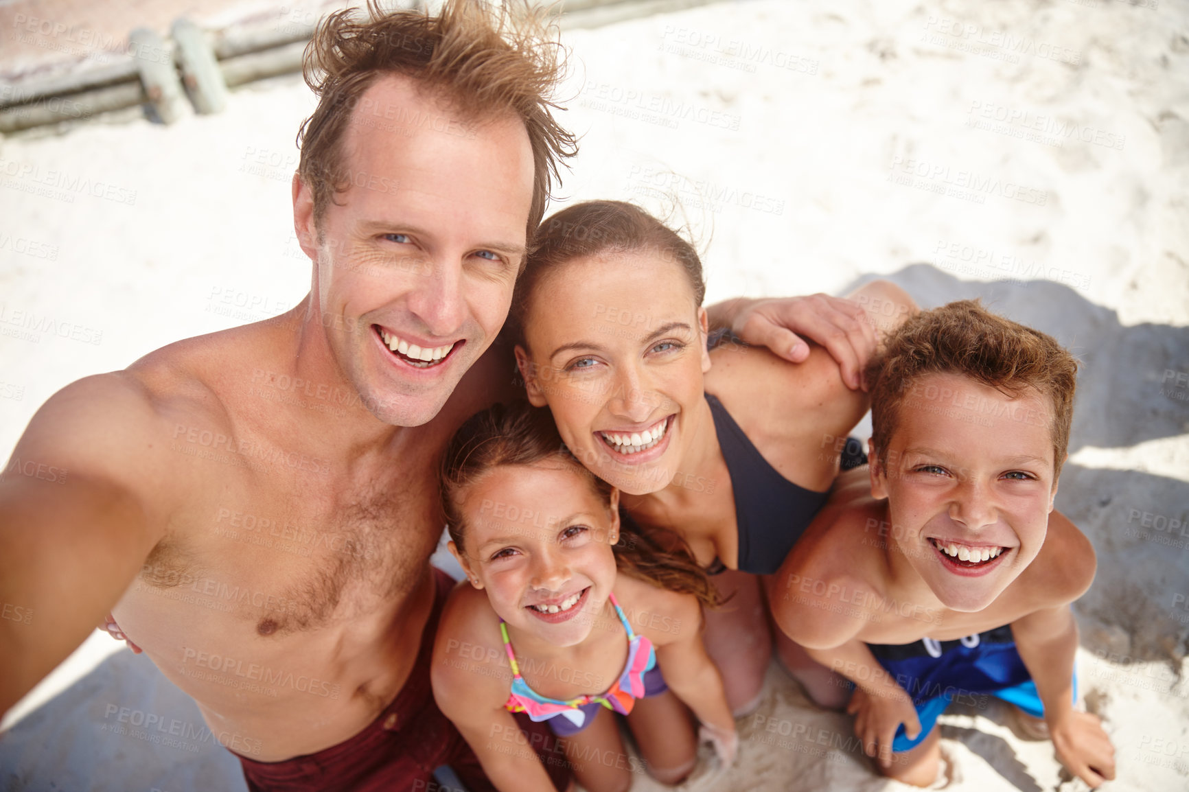 Buy stock photo A happy family taking a selfie at the beach