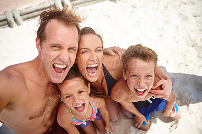 Buy stock photo A happy family taking a silly selfie at the beach