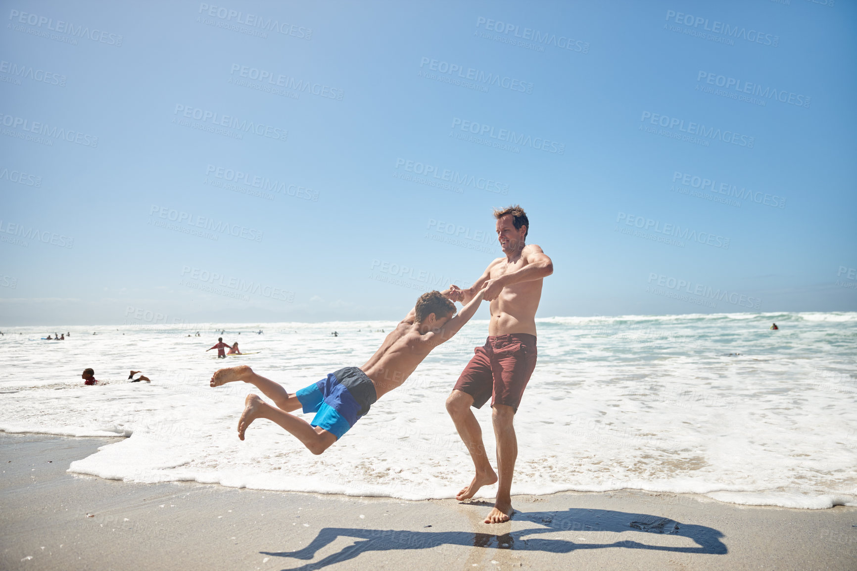 Buy stock photo Swing, dad and child on beach for travel, holiday and relax outdoors with playful game. Father, son and space with summer fun together by ocean for fresh air, vacation and weekend getaway in Greece