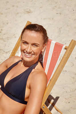 Buy stock photo Portrait of a beautiful young woman sitting on a chair on the beach