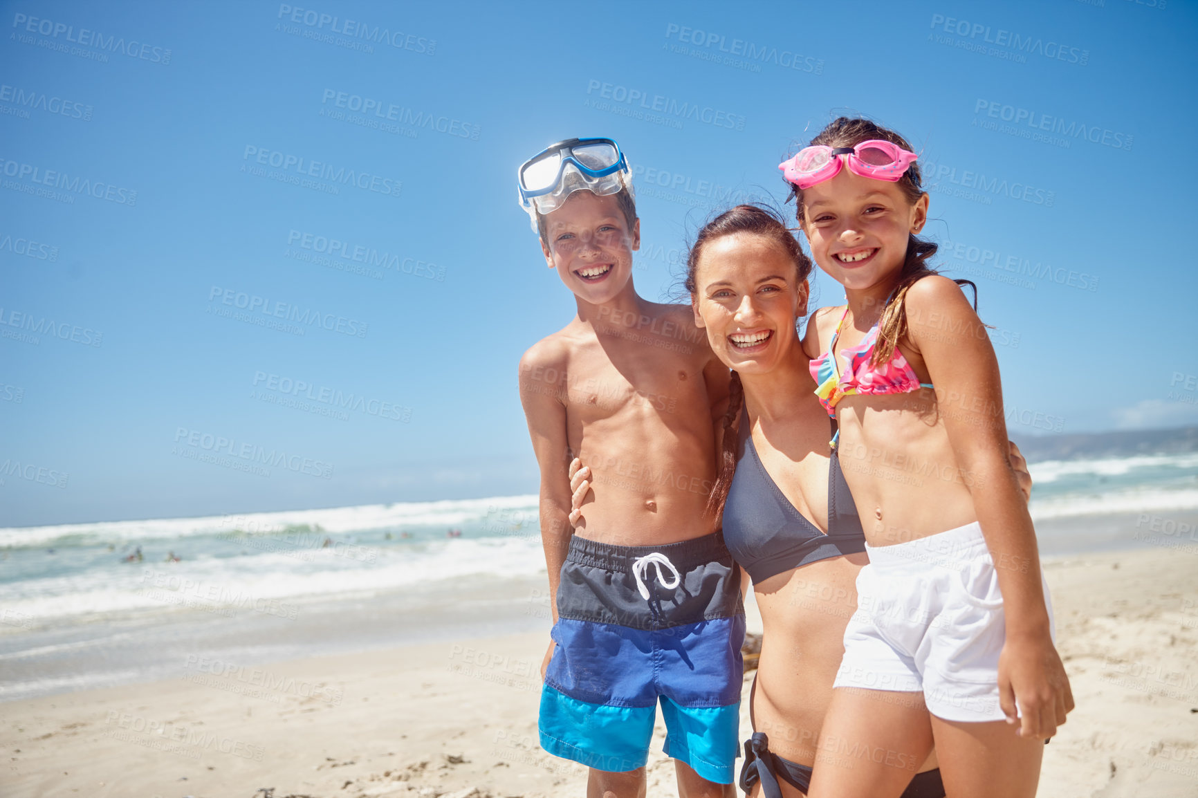 Buy stock photo Portrait of a mother standing with her two children on the beach