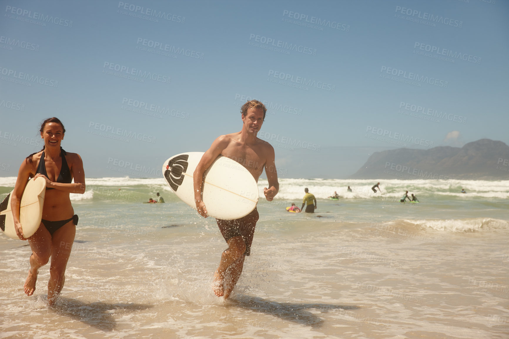 Buy stock photo Shot of a couple surfing together at their favourite beach