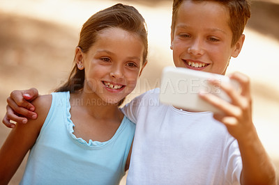 Buy stock photo Shot of a brother and sister taking a selfie together on a camping trip in the forest