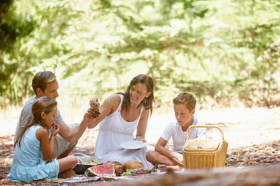 Buy stock photo Shot of a happy family having a picnic in the forest