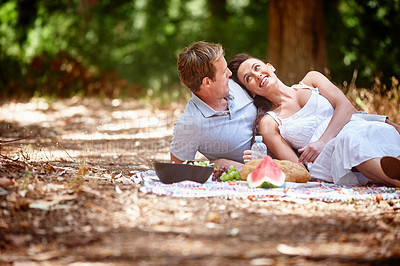 Buy stock photo Shot of an affectionate couple enjoying a picnic in the forest