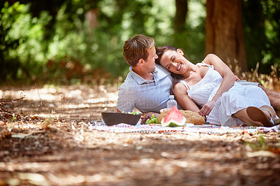 Buy stock photo Shot of an affectionate couple enjoying a picnic in the forest