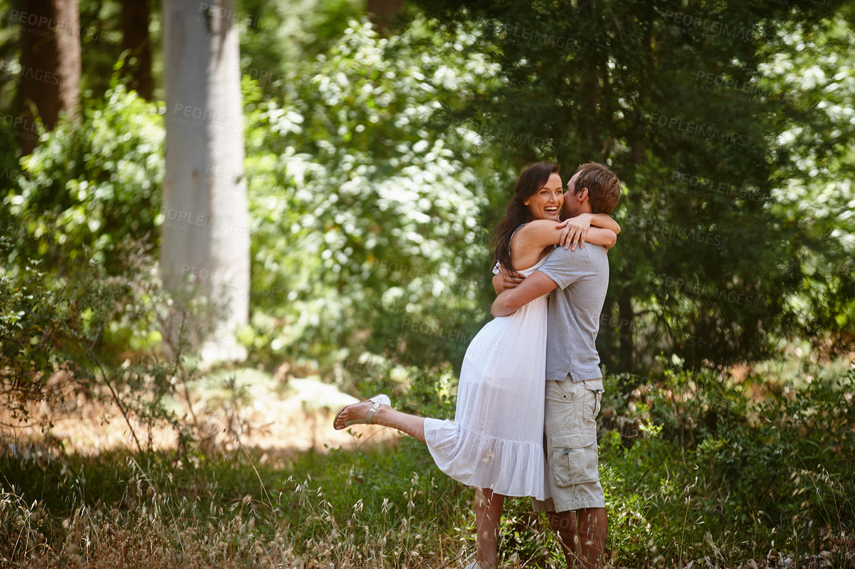 Buy stock photo Shot of a happy couple enjoying a carefree day together in the forest