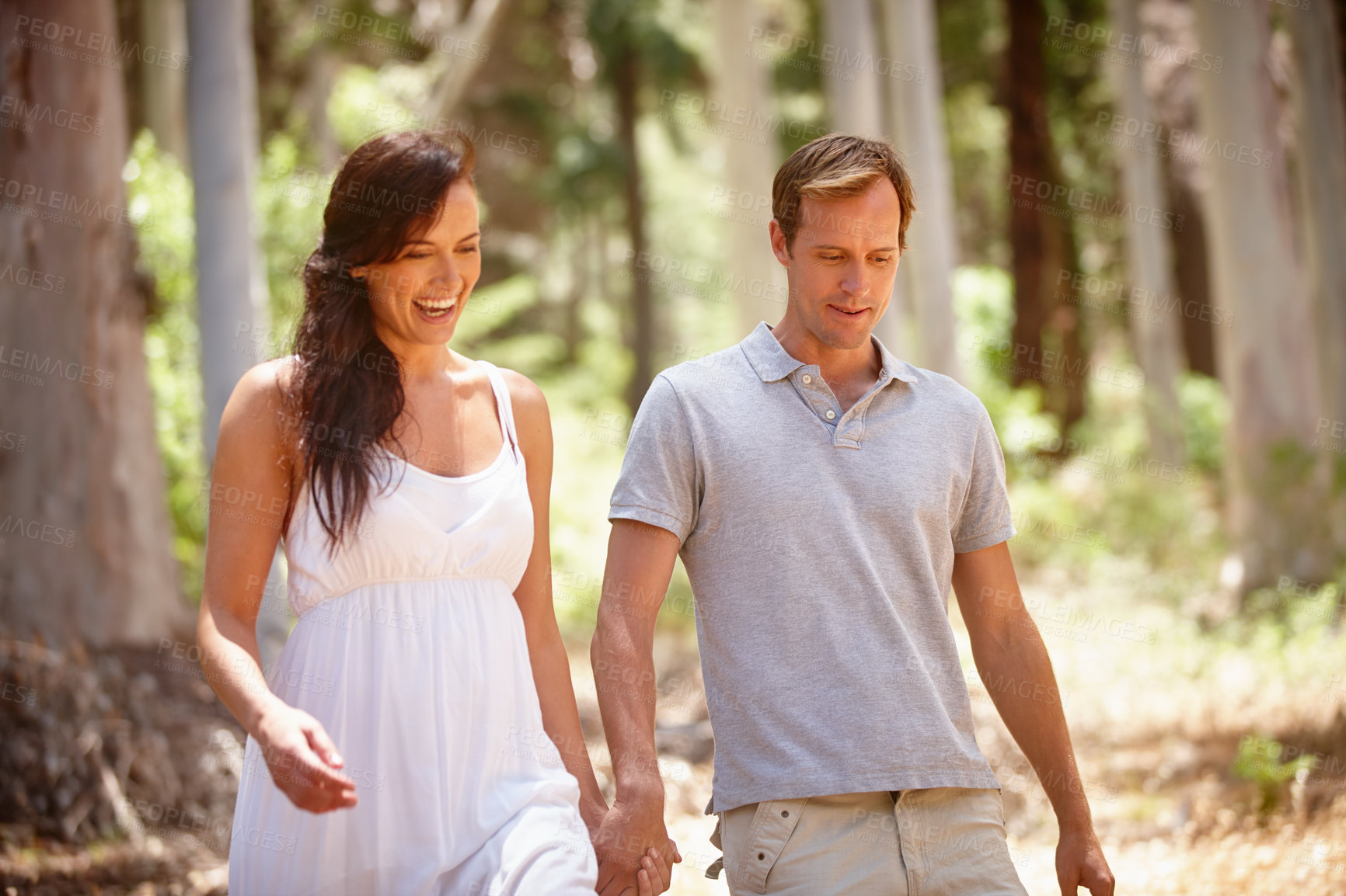 Buy stock photo Holding hands, laugh and couple in forest for love, healthy relationship and happy on vacation. Man, woman and walking in woods outdoor on romantic date, funny joke or talking on holiday for travel