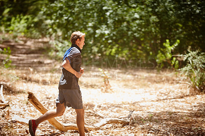 Buy stock photo Shot of a man jogging in a forrest 