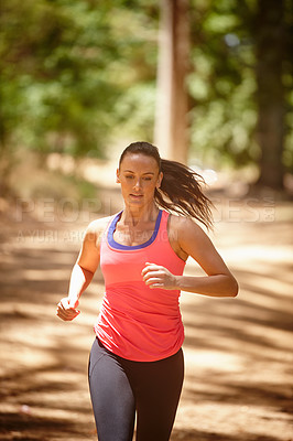 Buy stock photo Cropped shot of an attractive woman jogging in a forest
