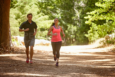 Buy stock photo Full length shot of a couple jogging in the forest