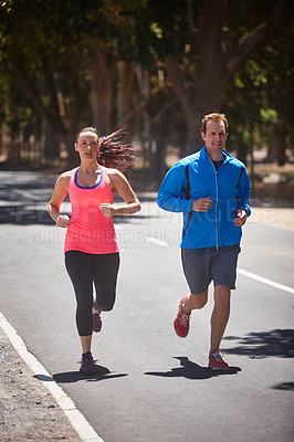 Buy stock photo Full length shot of a couple jogging on a road