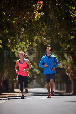 Buy stock photo Full length shot of a couple jogging on a road