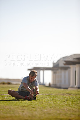 Buy stock photo Shot of a man doing stretches before his workout