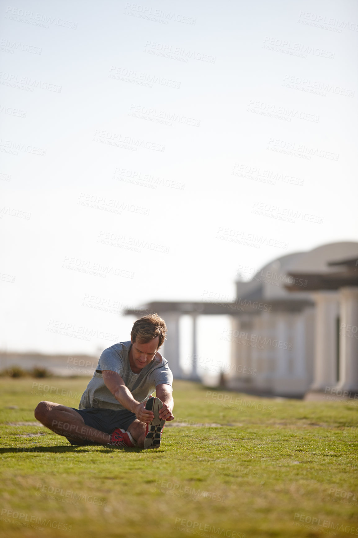 Buy stock photo Shot of a man doing stretches before his workout