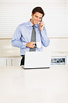 Business executive using cellphone while at the kitchen
