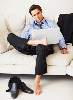 Buy stock photo Businessman, laptop and serious on sofa with relax in living room of home for email, networking and research. Entrepreneur, person and technology on couch of lounge for planning and project search