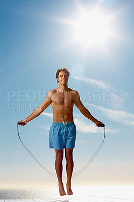 Buy stock photo Man, shirtless or rope skipping for fitness in summer workout, muscle or happy on vacation. Model, smile or training for natural glow of sport, cardio exercise or sunshine holiday by sky background
