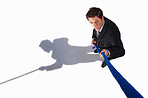 A young business man pulling a rope isolated on white