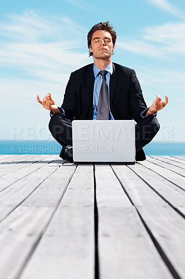 Buy stock photo Laptop, meditation and a business man outdoor on a pier by the ocean for mindfulness or stress relief for job. Computer, yoga and a young corporate employee by the sea for remote work or balance