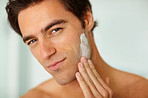 Closeup of a young man applying shaving cream to face