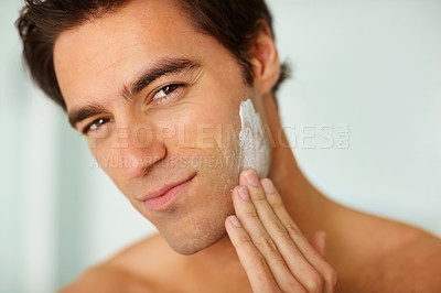 Buy stock photo Portrait, skincare and cream with a man in the bathroom of his home for morning routine or treatment. Face, beauty and lotion with a person in his apartment to apply moisturizer for skin hydration