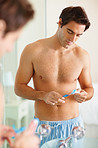 Sexy young man applying paste to his toothbrush