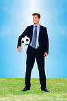 Young executive with a football in hand looking at copyspace