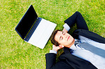 Relaxing - Businessman lying on grass with a laptop