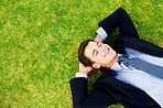 Dreaming - Young business man sleeping on grass and smiling