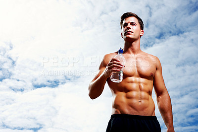 Buy stock photo Handsome young masculine man with a water bottle against cloudy sky - Looking at copyspace
