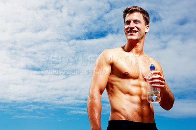 Buy stock photo Portrait of a happy young man looking away while holding a bottle of water against sky
