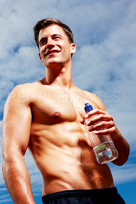 Buy stock photo Portrait of a smart young guy looking away while holding a bottle of water against sky
